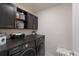 Modern laundry room featuring a dark countertop, shelving, and new appliances at 8985 Royal River Cir, Parrish, FL 34219