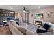 Comfortable living room featuring a fireplace, a gray sectional, and a staircase in the background at 8985 Royal River Cir, Parrish, FL 34219