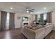 Cozy living room featuring a fireplace, large sectional, and lots of natural light with hardwood floors at 8985 Royal River Cir, Parrish, FL 34219
