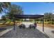 A lovely picnic area with a shaded structure, picnic tables, and a playground in the background at 8985 Royal River Cir, Parrish, FL 34219