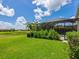 A beautiful backyard featuring a manicured lawn, screened pool, and lush landscaping at 10120 Carnoustie Pl, Bradenton, FL 34211