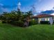 Lush backyard with a screened pool area, palm trees, and well-manicured lawn at 10120 Carnoustie Pl, Bradenton, FL 34211