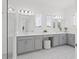 Bright bathroom features dual sinks, gray cabinets, and a glass-enclosed shower at 10120 Carnoustie Pl, Bradenton, FL 34211