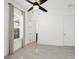 Light filled bedroom features a ceiling fan, tile floors, and an open doorway at 10120 Carnoustie Pl, Bradenton, FL 34211