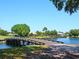 Scenic golf course view with a wooden bridge over water, lush greenery, and beautiful homes in the background at 10120 Carnoustie Pl, Bradenton, FL 34211