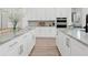 Expansive modern kitchen featuring dual islands, granite countertops, and bright, white cabinetry at 10120 Carnoustie Pl, Bradenton, FL 34211