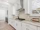 Modern kitchen features stainless steel range hood, granite countertops, and white cabinetry at 10120 Carnoustie Pl, Bradenton, FL 34211