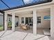 Covered patio featuring an outdoor seating area with a fireplace and television at 10120 Carnoustie Pl, Bradenton, FL 34211