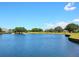 Serene view of a pond on the golf course, surrounded by lush greenery and beautiful homes in the distance at 10120 Carnoustie Pl, Bradenton, FL 34211