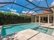 Large screened-in pool featuring a hot tub and lush landscaping for privacy at 10120 Carnoustie Pl, Bradenton, FL 34211