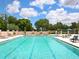 Inviting swimming pool with lounge chairs and umbrellas, perfect for relaxation and recreation in the sun at 10120 Carnoustie Pl, Bradenton, FL 34211