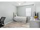 Well-lit bedroom with light green walls, wood-look floors, and neutral beddings, creating a serene space at 1107 22Nd E St, Palmetto, FL 34221