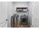 Modern laundry room featuring stainless steel washer and dryer units and a decorative shelf at 1107 22Nd E St, Palmetto, FL 34221
