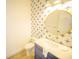 Charming half bathroom with a patterned accent wall, vanity, and a round mirror at 111 6Th N St, Bradenton Beach, FL 34217
