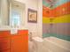Colorful bathroom with a shower-tub combination and unique tiled walls at 111 6Th N St, Bradenton Beach, FL 34217