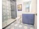 Beautiful bathroom boasting patterned tile floor, glass shower, and blue vanity with white countertop at 111 6Th N St, Bradenton Beach, FL 34217