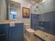 Well-lit bathroom with blue accents and a glass-enclosed shower with tiled walls at 111 6Th N St, Bradenton Beach, FL 34217