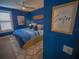 Stylish bedroom with blue walls, wood flooring, and a queen-sized bed with blue bedding at 111 6Th N St, Bradenton Beach, FL 34217