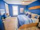 Bright bedroom featuring wood floors, blue walls, and a queen-sized bed with blue bedding at 111 6Th N St, Bradenton Beach, FL 34217