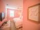 Cozy bedroom with pink accents, a queen bed, and a decorative 'Coral Reef Suite' sign at 111 6Th N St, Bradenton Beach, FL 34217