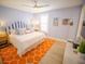 Cozy bedroom with a queen-size bed, striped headboard, and orange patterned rug at 111 6Th N St, Bradenton Beach, FL 34217