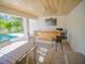 Outdoor covered bar with a TV and dining table that overlooks the pool area at 111 6Th N St, Bradenton Beach, FL 34217