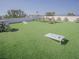 Wide angle view of rooftop deck with artificial grass, tables, chairs, and cornhole game at 111 6Th N St, Bradenton Beach, FL 34217