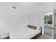 Minimalist bedroom with sleek bed frame, white linens, and poolside access through glass doors at 1168 Westway Dr, Sarasota, FL 34236