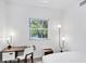 Bright bedroom with a modern desk, minimalist lighting, and views of lush greenery outside the window at 1168 Westway Dr, Sarasota, FL 34236