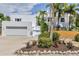 Well-maintained white home with palms and green landscaping, including driveway and attached garage at 1168 Westway Dr, Sarasota, FL 34236