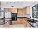 Spacious kitchen equipped with stainless steel refrigerator, built-in microwave, natural wood cabinets, and light-colored flooring at 1168 Westway Dr, Sarasota, FL 34236
