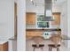 Bright kitchen featuring modern stainless steel range hood, light wood cabinetry, and breakfast bar with stylish seating at 1168 Westway Dr, Sarasota, FL 34236