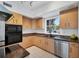 Well-lit kitchen showcasing stainless steel appliances, dark countertops, natural wood cabinets, and tiled floor at 1168 Westway Dr, Sarasota, FL 34236