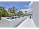 A rooftop deck featuring modern outdoor seating with a view of the lush tropical surroundings and blue sky at 1168 Westway Dr, Sarasota, FL 34236