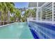 Swimming pool with an integrated water feature and tiled edge, surrounded by palm trees and a deck with a white railing at 1168 Westway Dr, Sarasota, FL 34236