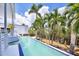 Backyard swimming pool lined with mature palm trees and tropical landscaping, offering a serene outdoor oasis at 1168 Westway Dr, Sarasota, FL 34236
