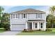 Inviting two-story home with a two-car garage, gray shutters, and a beautifully landscaped front yard at 12044 Kingsley Trl, Parrish, FL 34219