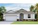 Charming single-story home featuring stone accents, a two-car garage and well-manicured landscaping at 12048 Kingsley Trl, Parrish, FL 34219