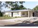 Charming single-story home featuring a light exterior, carport, tidy landscaping, and a freshly sealed driveway at 1207 65Th Nw St, Bradenton, FL 34209