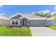Attractive single-story home with a two-car garage, gray siding, well-kept lawn and a front garden at 12071 Mountain Island Trl, Parrish, FL 34219