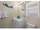 Cozy bathroom with beach themed decor, single sink vanity and a window for natural light at 123 52Nd St # B, Bradenton Beach, FL 34217