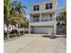 Charming two-story home featuring a spacious garage, balcony, and meticulously landscaped yard with mature palm trees at 123 52Nd St # B, Bradenton Beach, FL 34217