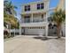 Charming two-story home featuring a spacious garage, balcony, and mature palm trees at 123 52Nd St # B, Bradenton Beach, FL 34217