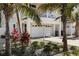 View of the exterior featuring a spacious garage and tropical landscaping with multiple palm trees at 123 52Nd St # B, Bradenton Beach, FL 34217