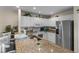 Bright kitchen featuring granite countertops, white cabinetry, and stainless steel appliances at 123 52Nd St # B, Bradenton Beach, FL 34217