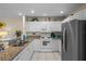 Bright kitchen featuring granite countertops, white cabinetry, and stainless steel appliances at 123 52Nd St # B, Bradenton Beach, FL 34217