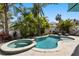 Beautiful backyard pool and jacuzzi surrounded by lush landscaping, offering a private tropical oasis at 123 52Nd St # B, Bradenton Beach, FL 34217