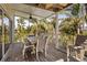 Enjoy outdoor dining in the spacious screened porch, featuring an outdoor table and chairs with tropical views at 123 52Nd St # B, Bradenton Beach, FL 34217