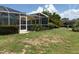 Fenced backyard featuring an enclosed porch and green space with landscaping at 134 Gulfview Rd, Punta Gorda, FL 33950