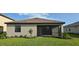 Rear exterior with a screened-in porch overlooking a manicured lawn and tidy landscaping at 15127 Oxford Grey Dr, Bradenton, FL 34211